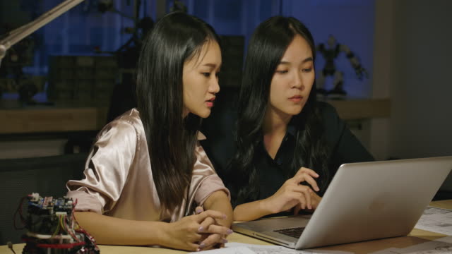 Woman-Electronics-Engineers-Examining-Project-At-Office.-Two-Asian-Female-Compare-Data-On-a-Personal-Computer.-People-with-technology-or-innovation-concept.