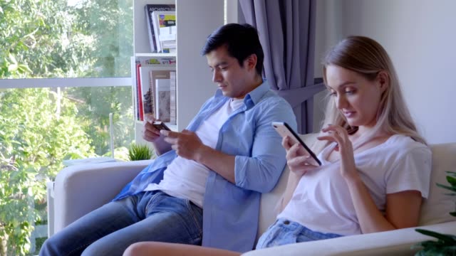 Familie-lacht-und-schaut-Selfie-auf-Smartphone-im-Wohnzimmer