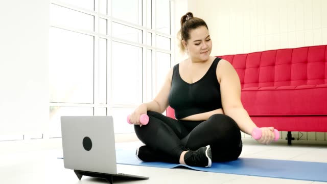 Übergewichtige-junge-Frau-in-Sportbekleidung-trainieren,-um-Gewicht-zu-Hause-zu-verlieren