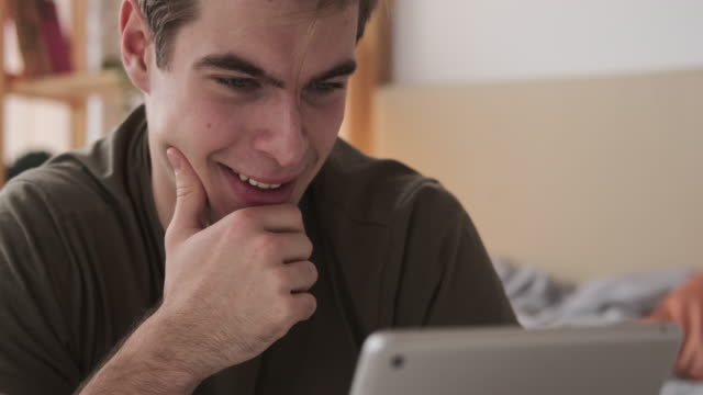 Hombre-feliz-usando-tableta-digital-en-casa