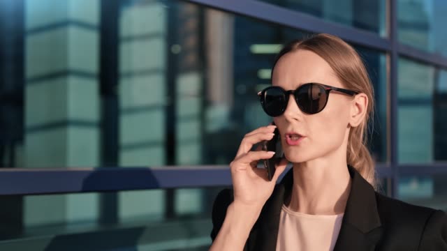Closeup-zuversichtlich-Business-Lady-gehen-in-der-Innenstadt-sprechen-mit-Smartphone.-4k-Dragon-RED-Kamera