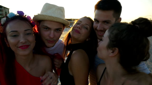 Group-of-friends-making-funny-faces-on-video-call-at-the-beach