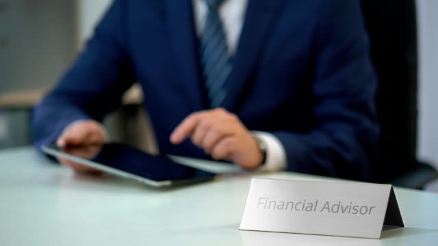 Männlicher-Finanzberater-arbeitet-auf-Tablet-PC,-macht-Investitionsplan-für-Kunden