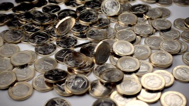 ein-Euro-Münzen-fallen-auf-weißem-Hintergrund