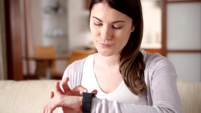 Woman-at-home-texting-on-smart-watch.-Beautiful-young-female-professional-working-on-smartwatch