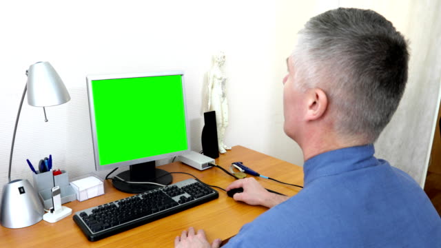 Arzt-arbeitet-an-einem-Computer-mit-einem-green-screen