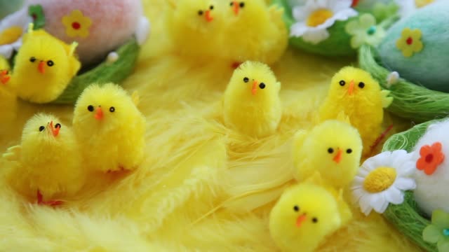 Bebé-amarillo-Pascua-juguetes-polluelos-y-huevos-sobre-un-fondo-de-plumas.-Tarjeta-de-felicitación-video-fiesta