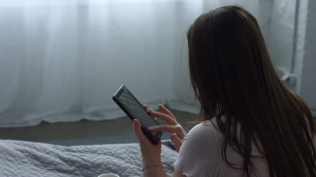 Erwachsene-Frau-mit-TabletPC-sitzen-auf-dem-Bett