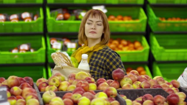 Frau-im-Rollstuhl,-die-Äpfel-im-Supermarkt-zu-kaufen