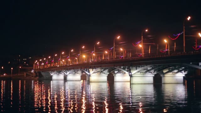 Chernavsky-puente-con-iluminación-por-las-noches-y-el-reflejo-de-luces-en-el-agua,-Voronezh