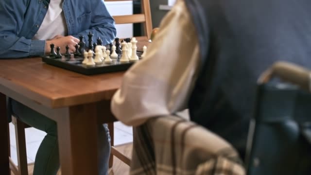 Großvater-spielt-Schach-mit-Erwachsenen-Enkel