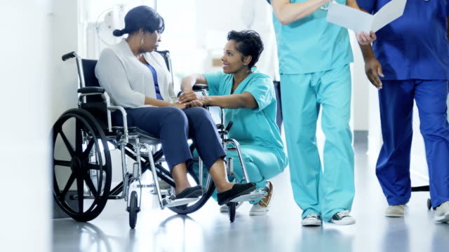 African-American-mujer-médico-y-paciente-en-silla-de-ruedas