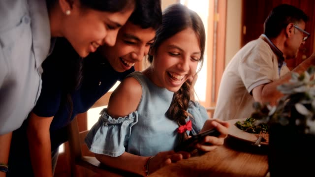 Multi-ethnic-children-having-fun-watching-online-videos-on-smartphone