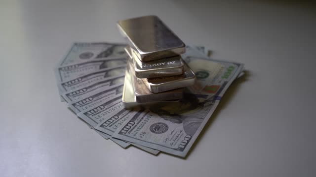 Silver-Bars-on-Top-of-Hundred-Dollar-Bills-Zooming-In