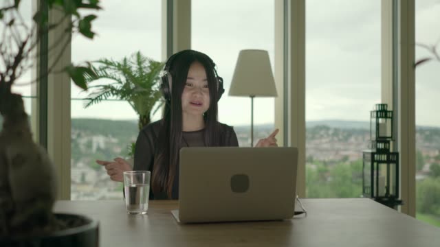 Young-woman-sitting-at-home-working-with-computer-and-chair-dancing