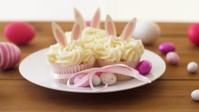 Cupcakes-mit-Ostereiern-und-Süßigkeiten-auf-Tisch