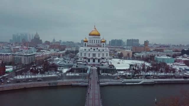 Aerial-shot-of-russian-Orthodox-Cathedral-of-Christ-the-Savior-in-Moscow---the-view-from-Moscow-river-and-bridge.-Winter.-On-background-Stalins-skyscrapers-and-Moscow-city.