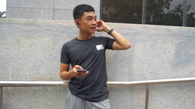 Hombre-asiático-usando-smartphone-al-aire-libre