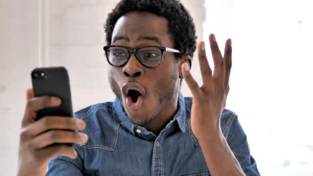 Excited-Man-Enjoying-Success-while-Using-Smartphone