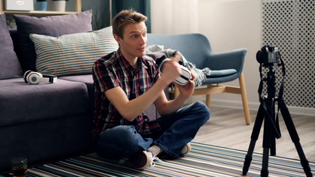 Junge-Mann-Blogger-ist-Aufzeichnung-von-Video-über-Virtual-Reality-Brillen-auf-dem-Boden-zu-Hause-sitzen