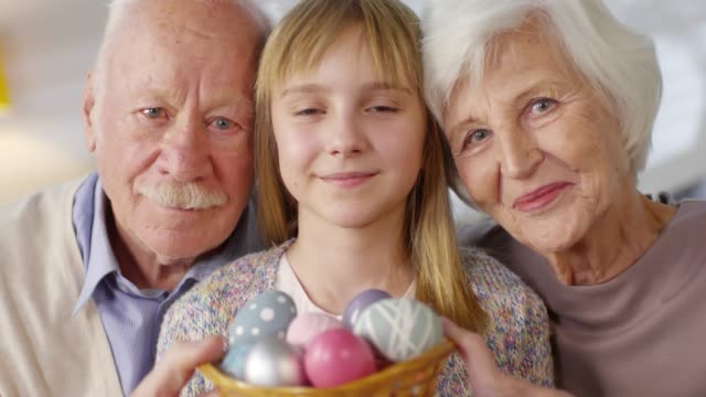 Portrait-of-Granddaughter-and-Grandparents-with-Easter-Eggs