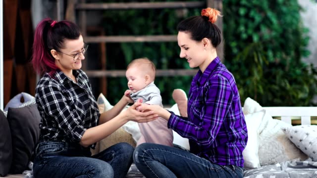 Female-parents-enjoying-playing-with-little-cute-son-smiling-and-relaxing-together-at-home