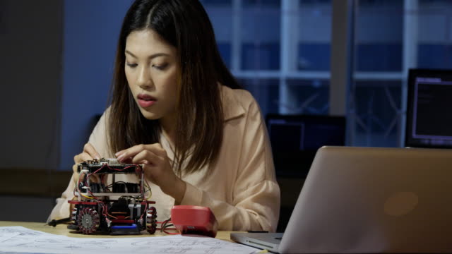 Female-electronics-engineer-working-with-robot-project-at-lab.-Technology-and-innovation-concept.