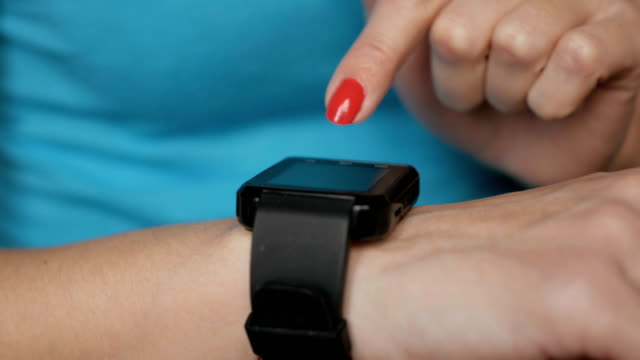 Frau-mit-ihrem-Smartwatch-Touchscreen-tragbare-Technologie-Gerät.-Frau-mit-ihrem-Smartwatch-Touchscreen-tragbare-Technologie-Gerät.-Mädchen-machen-Gesten-auf-einer-tragbaren-Smartwatch,-aus-nächster-Nähe.
