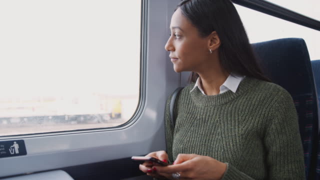 Geschäftsfrau-sitzt-im-Zug-Pendeln-zur-Arbeit-Überprüfen-von-Nachrichten-auf-Dem-Handy