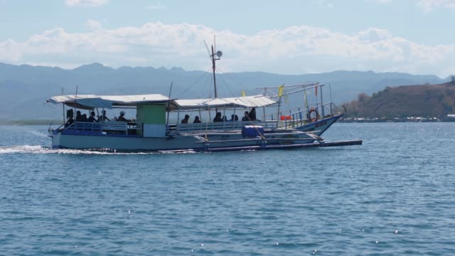 Kleines-Boot-mit-Touristen-reisen-auf-dem-blauen-Ozean-auf-eine-schöne-Insel.