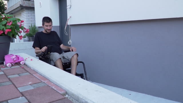 Vídeo-de-cámara-lenta-de-un-hombre-en-silla-de-ruedas-eléctrica-utilizando-una-rampa-en-una-casa-accesible