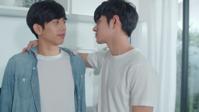 Asian-Gay-couple-standing-and-hugging-room-at-home.-Young-handsome-LGBTQ+-men-kissing-happy-relax-rest-together-spend-romantic-time-in-modern-kitchen-at-house-in-the-morning-concept.
