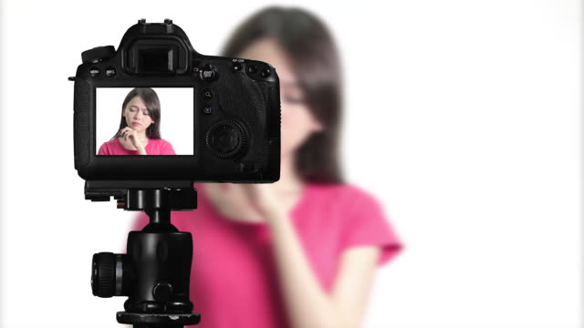 Asian-American-woman-having-eureka-moment-on-camera,-creating-content-for-social-media