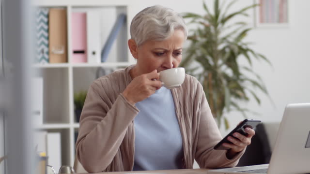Middle-aged-Woman-Having-Coffee-Break-on-Workplace