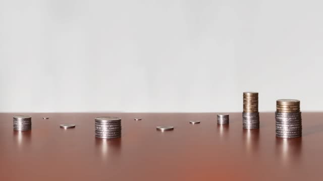 Viele-Münzen-im-Zeitraffer-auf-dem-Holztisch
