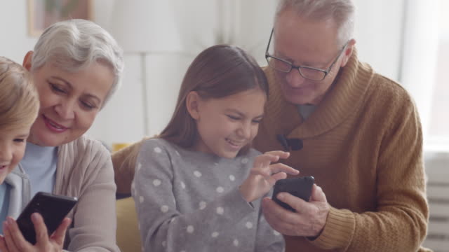 Niños-usando-gadgets-con-abuelos