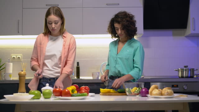 Dos-hembras-cortando-verduras-orgánicas,-cocinando-ensalada-en-casa,-uniendo