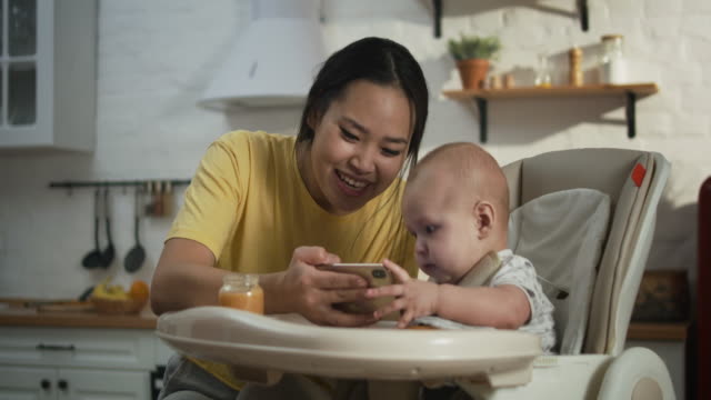Mother-showing-smartphone-to-baby