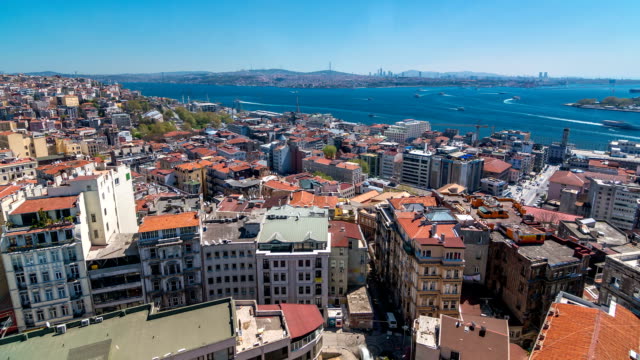 The-view-from-Galata-Tower-to-Golden-Horn-and-Bosphorus,-city-skyline-with-red-roofs-timelapse,-Istanbul,-Turkey