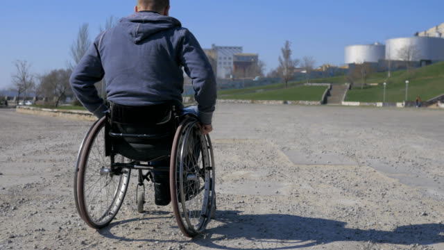 Difficulty-traveling-wheelchair-on-street,-handicapped-makes-failed-attempts-steer-wheelchair,-Disabled-man-in-wheelchair