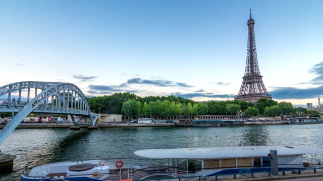 Eiffel-tower-with-Debilly-Footbridge-and-Jena-bridge-over-Seine-river-day-to-night-timelapse,-Paris,-France