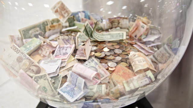 A-lot-of-different-bills---money-of-different-countries-in-big-glass-jar