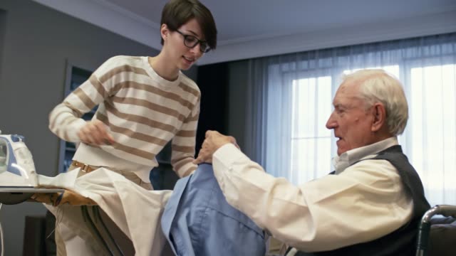 Mujer-joven-ayudando-a-hombre-mayor-con-las-tareas-domésticas