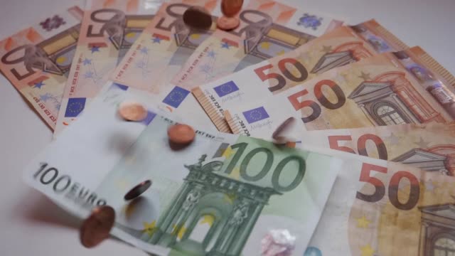 Muchas-monedas-y-billetes,-euros,-dinero