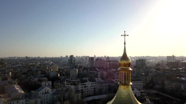 A-bird's-eye-view,-panoramic-video-from-the-drone-in-FullHD-to-the-the-golden-dome-of-Saint-Sophia's-Cathedral-in-the-city-of-Kiev,-Ukraine-against-a-bright-sun.