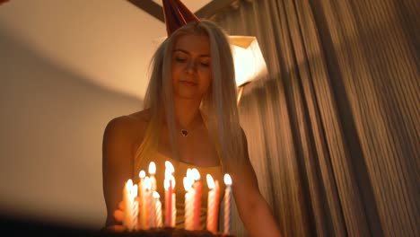 Atrtactive-smiling-woman-looking-at-man-lighting-candles-on-birthday-cake