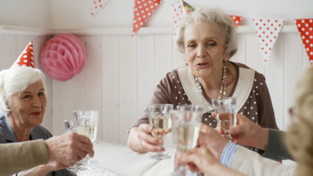 Elderly-Lady-Toasting-with-Friends-at-Holiday-Dinner
