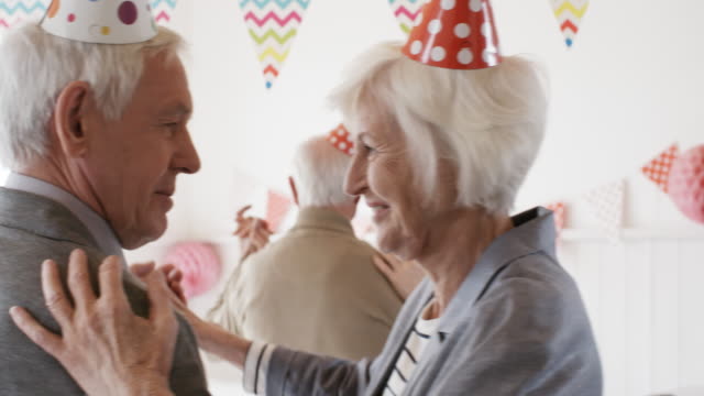 Fröhliche-Senioren-Paare-tanzen-auf-Geburtstagsparty