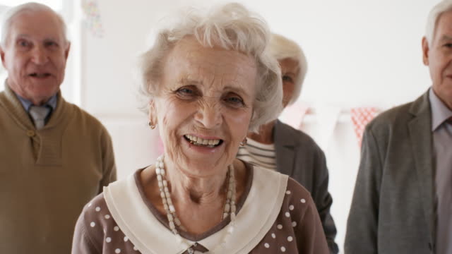 Glücklich-Senior-Lady-posiert-für-die-Kamera-auf-Geburtstagsparty