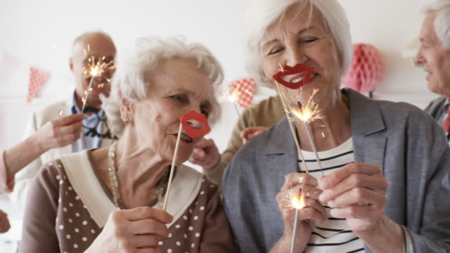 Ältere-Damen-mit-Wunderkerzen-auf-Party-tanzen